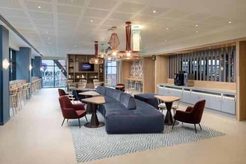 a lobby with a couch and tables and a bar at Hampton By Hilton Rochdale in Rochdale