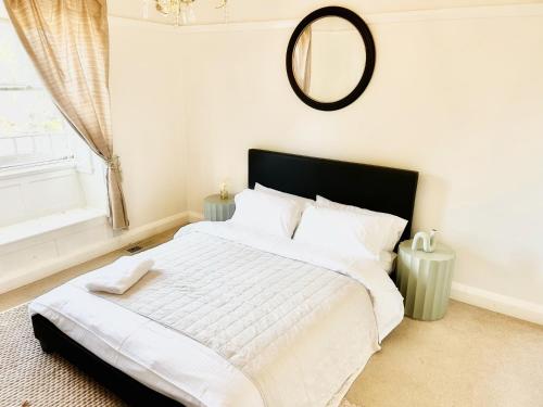1 dormitorio con 1 cama grande y espejo en la pared en Lurline Lodge en Katoomba