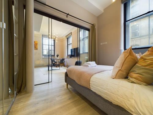a bedroom with a bed and a large window at Luxury Stunning 2bedroom city centre in Manchester