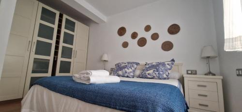 1 dormitorio con 1 cama con manta azul y almohadas en Piso familiar y con encanto, en Sevilla