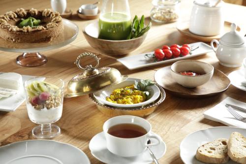een houten tafel met borden met eten en een kopje thee bij Gerês - Leiras do Tempo - Cottages in Brufe
