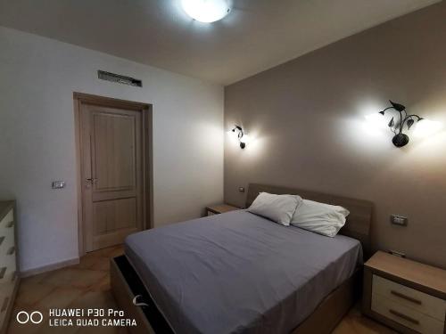 - une chambre avec un lit et deux lumières sur le mur dans l'établissement Le castellane, à Castelsardo