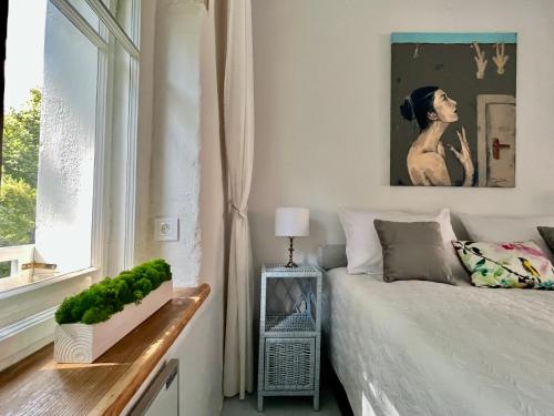 a white bedroom with a bed and a window at Dom w murach in Lwówek Śląski