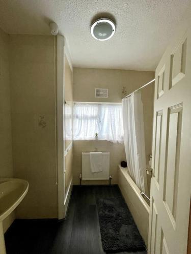 a bathroom with a sink and a shower and a window at Stylish Four Bed City Retreat in Birmingham