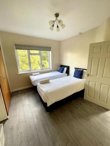 een slaapkamer met 2 bedden en een raam bij Stylish Four Bed City Retreat in Birmingham