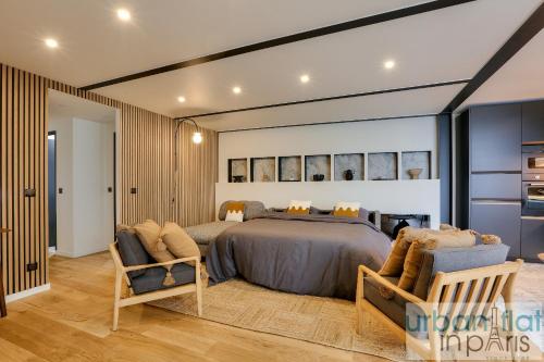 une chambre avec un grand lit et deux chaises dans l'établissement 170 - Sublime Flat in Center of Paris, à Paris