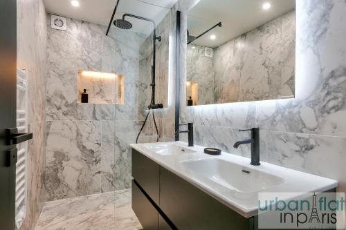 une salle de bain avec un lavabo et un miroir dans l'établissement 170 - Sublime Flat in Center of Paris, à Paris