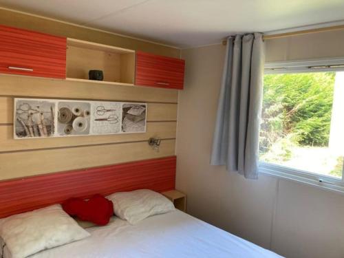 1 dormitorio con cama blanca y ventana en Mobil home Confortable et Lumineux 50 min de Paris, en Mirgaudon