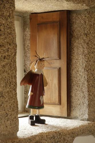 a figurine of a woman standing in front of a door at Leiras do Tempo - Adults Nature Retreat - Cottages - Gerês National Park in Brufe