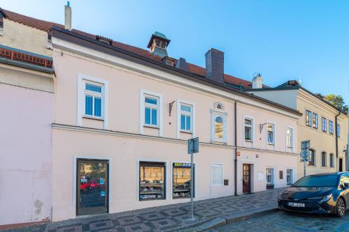 a white building with a car parked in front of it at The Bookhouse, 5-bedroom residence by Prague Castle in Prague