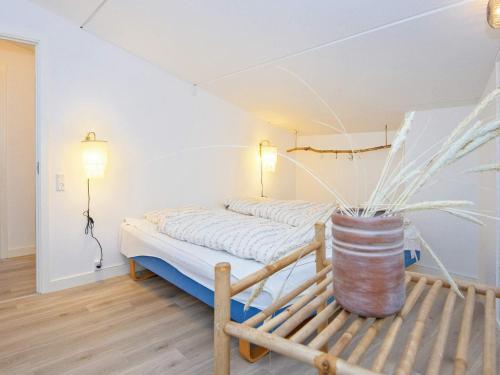 a bedroom with a bed and a vase on a bench at 8 person holiday home in Ringkøbing-By Traum in Ringkøbing