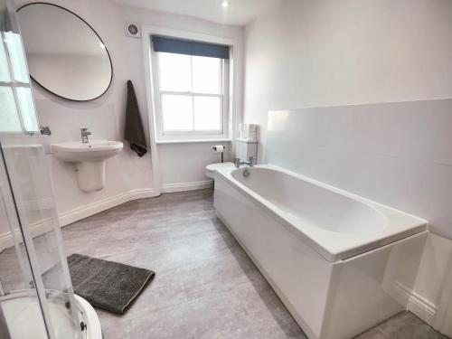 a bathroom with a tub and a sink and a mirror at 3 Bed Flat close to Liverpool st & Brick lane in London