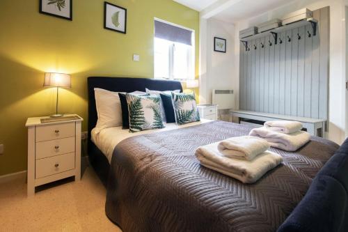 a bedroom with a bed with towels on it at Isis Lakes 84 - Tortola Lodge in South Cerney