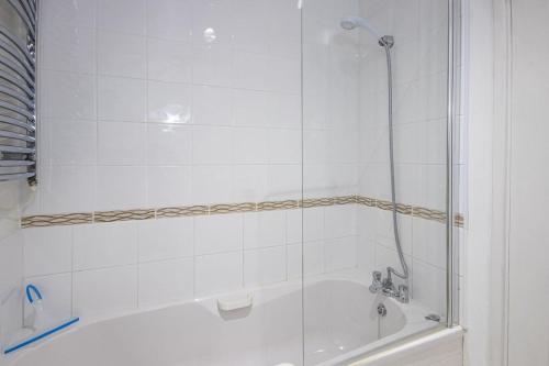 a white bathroom with a tub and a shower at Isis Lakes 84 - Tortola Lodge in South Cerney