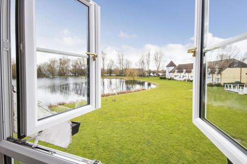 an open window with a view of a body of water at Isis Lakes 84 - Tortola Lodge in South Cerney