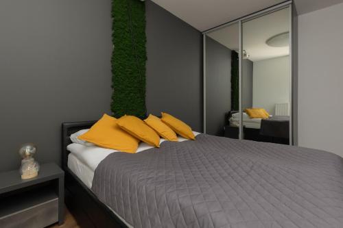1 dormitorio con 1 cama con almohadas amarillas en Modern Apartment Home Cinema Experience by Renters en Varsovia