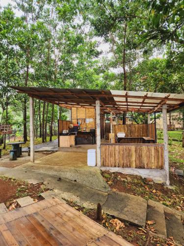 a wooden pavilion in a park with trees in the background at Isla Del Antoño in Cavinti