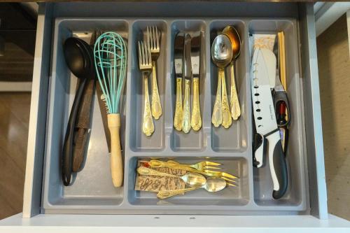 a tray filled with utensils and utensils at Petite City Centre Apartment in Šiauliai