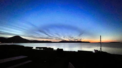 a view of a sunset over a body of water at Carnmhor, Isle of Skye - Stunning 242 year old cottage on its own sea shore! in Breakish