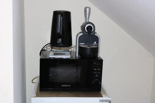 a microwave with a coffee maker on top of it at STUDIO TOUT CONFORT in Soignies
