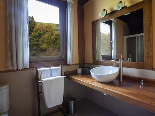 a bathroom with a bowl sink and a mirror at Hotel Rural Irati in Jaurrieta