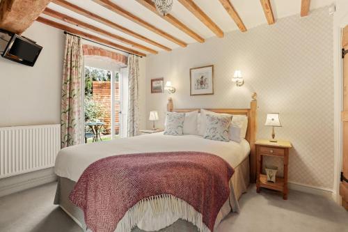 Un dormitorio con una cama grande y una ventana en Horseshoe Cottage Farm with Hot Tub, en Leicester