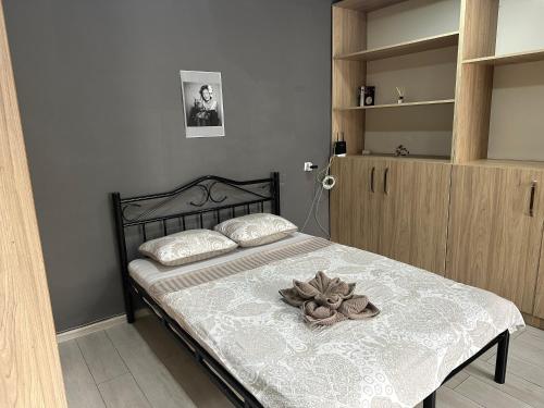 ein Schlafzimmer mit einem Bett mit einer Blume darauf in der Unterkunft Cozy flat in Tbilisi City