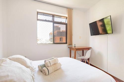 um quarto com uma cama, uma secretária e uma televisão em Quarto de Casal em Apartamento - Belo Horizonte - Buritis em Belo Horizonte