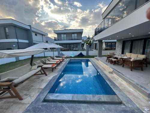 a swimming pool with chairs and umbrellas next to a building at AMY VILLAS in Antalya