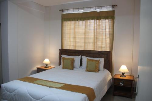 a bedroom with a large bed with two night stands at StayHome Away from Home in Cherrapunji