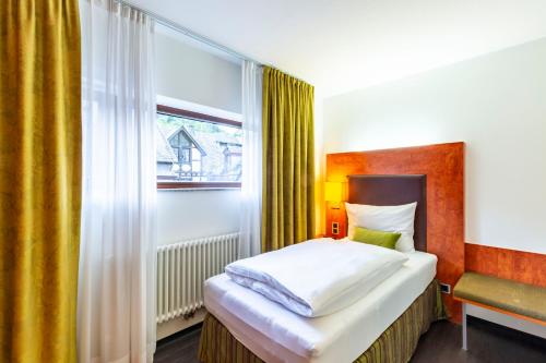 - une chambre avec un lit et une fenêtre dans l'établissement DAS WESEL - DEIN HOTEL AM RHEIN, à Oberwesel