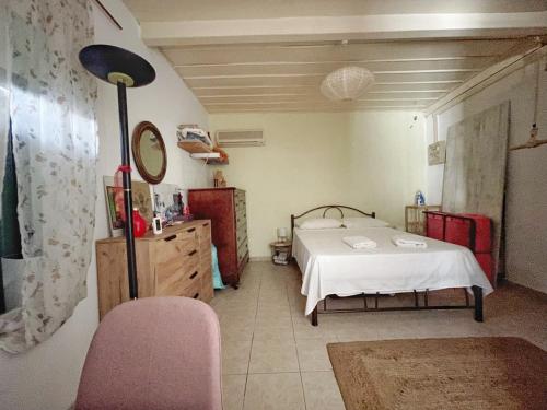a bedroom with a bed and a mirror and a chair at Filoxenos Houses Corfu Island in Mantoúkion
