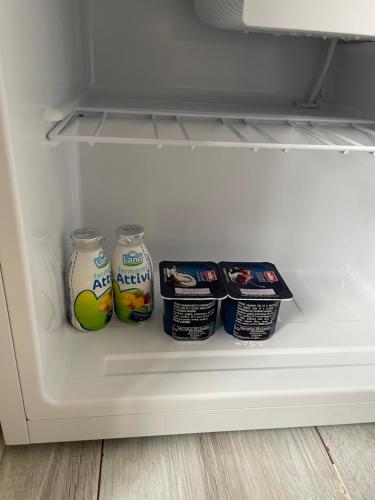 a refrigerator with two cans of yogurt and milk at Camera in centro storico in Olbia