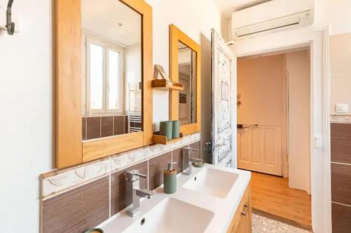 une salle de bain avec deux lavabos et un grand miroir dans l'établissement Peyerimhoff Colmar - 3 Chambres - 8 Pers - Clim, à Colmar