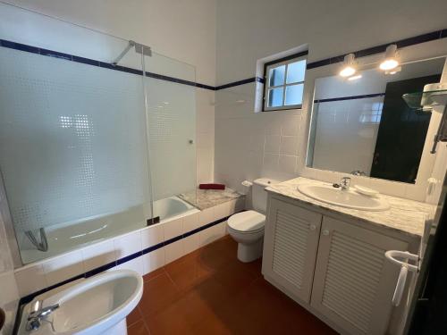 een badkamer met een wastafel, een bad en een toilet bij SA PUNTA GRAN A2 by SOM Menorca in Fornells
