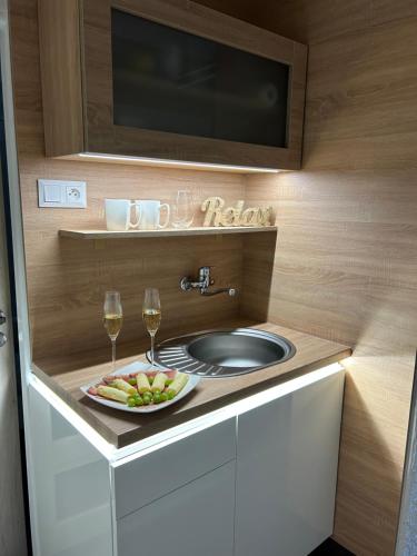 baño con lavabo y bandeja de fruta y copas de vino. en Komfortný apartmán s bazénom a súkromným parkoviskom-NONSTOP Check-in, en Banská Bystrica