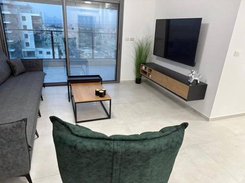 a living room with a couch and a flat screen tv at Elegant 3 bedroom Ocean view Condo in Kiryat Yam in Qiryat Yam
