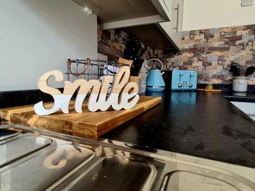 a kitchen counter with a smile sign on a cutting board at Tower Views 2 Bedroom House with Private Parking in Blackpool