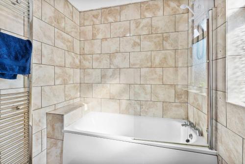 La salle de bains est pourvue d'une baignoire et d'une douche. dans l'établissement Stunning 5 Bed in Peak District Gem - Games Rooms, à Langley Mill