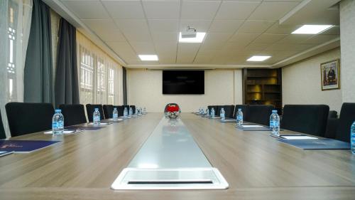 a conference room with a long table with chairs and water bottles at Razane Hôtel in Kenitra