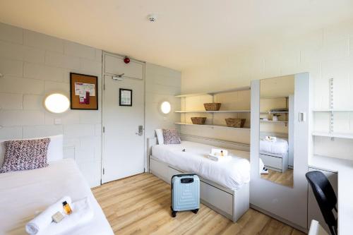 a small bedroom with two beds and a trash can at Corrib Village Apartments University of Galway in Galway