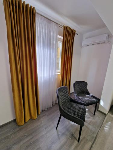 a room with two chairs and a window at Apartament AlyMit Băile Herculane in Băile Herculane