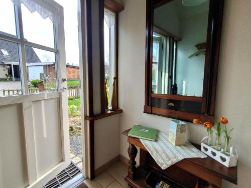 Habitación con espejo y mesa con ventana en Am Sund Hus, en Ulsnis