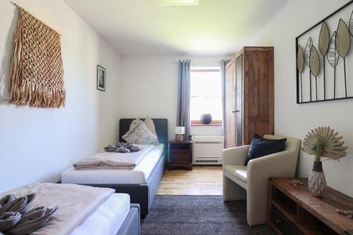 a bedroom with two beds and a couch and a chair at Naturtalente Berghaus - Apartment 2 in Innerschwand am Mondsee