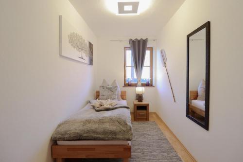 una camera con letto e specchio di Naturtalente Berghaus - Apartment 2 a Innerschwand