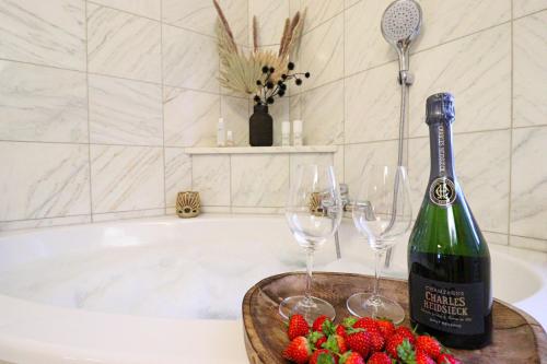 a bath tub with a bottle of wine and wine glasses at Naturtalente Berghaus - Apartment 2 in Innerschwand am Mondsee