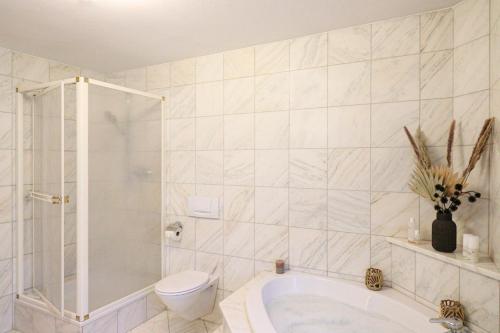 a bathroom with a toilet and a bath tub at Naturtalente Berghaus - Apartment 2 in Innerschwand am Mondsee