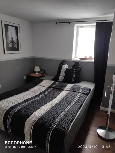 a bedroom with a black and white bed with a window at Annabell in Soest