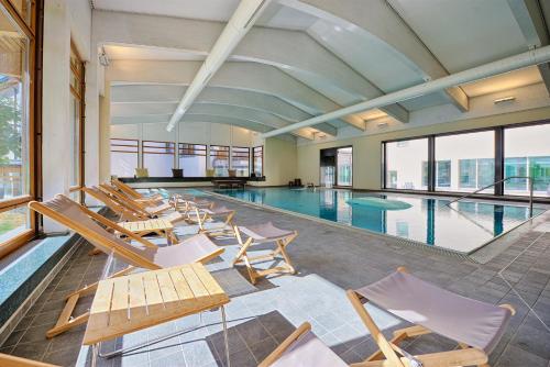 einen Pool mit Liegestühlen und einem Pool in der Unterkunft Schweizerhof Ferienwohnungen Lenzerheide 5 in Lenzerheide