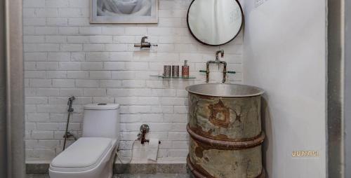een badkamer met een toilet, een wastafel en een spiegel bij Fun Factory in Rānchī